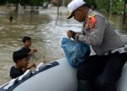 Personil Satlantas Polres Aceh Utara Bagikan Sarapan Pagi ke Korban Banjir Pakai Sampan